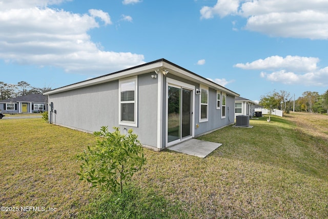 back of property featuring a yard and central air condition unit