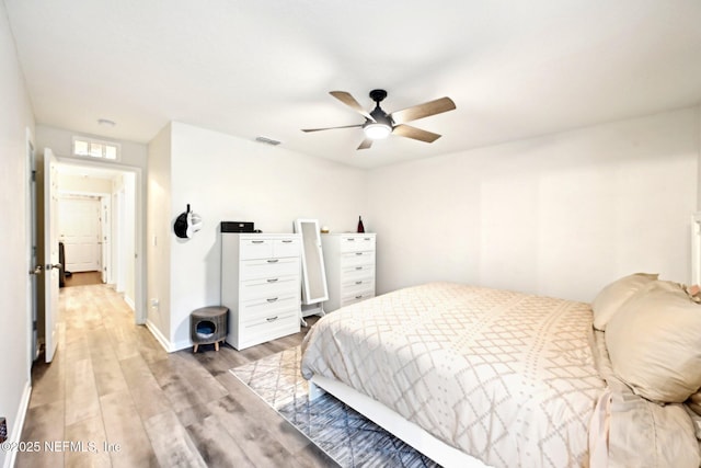 bedroom with light wood-type flooring, baseboards, visible vents, and a ceiling fan