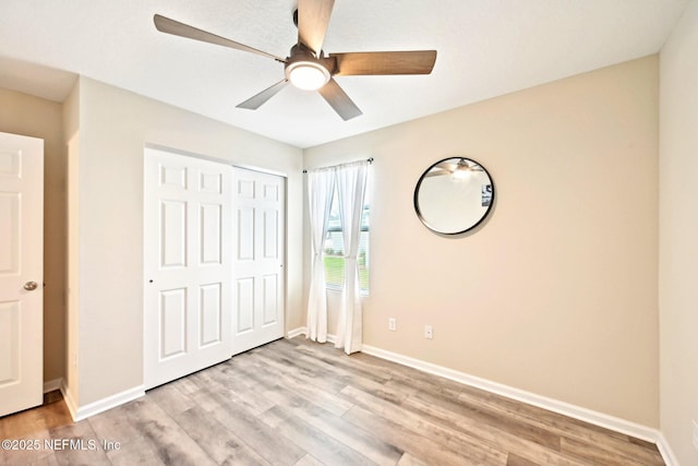 unfurnished bedroom with light wood-style floors, baseboards, and a closet