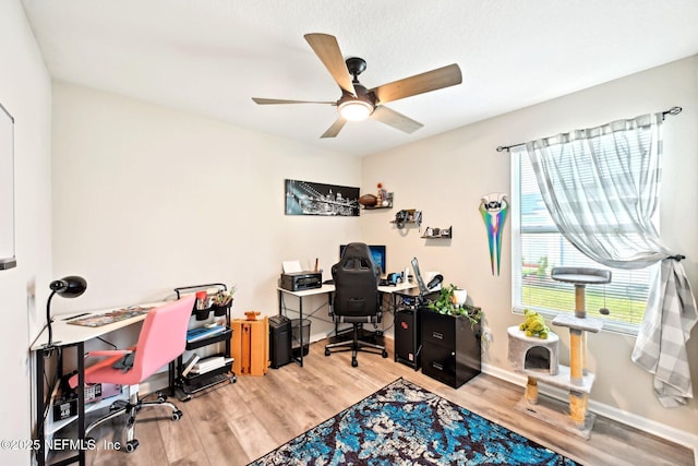 office area with a ceiling fan, baseboards, and wood finished floors