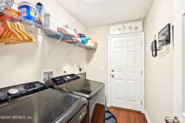 laundry area featuring laundry area, baseboards, dark wood-type flooring, a textured ceiling, and separate washer and dryer