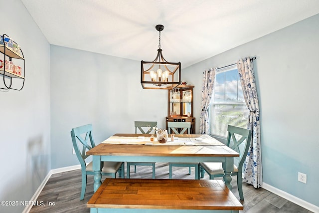 dining area featuring a notable chandelier, baseboards, and dark wood-style flooring