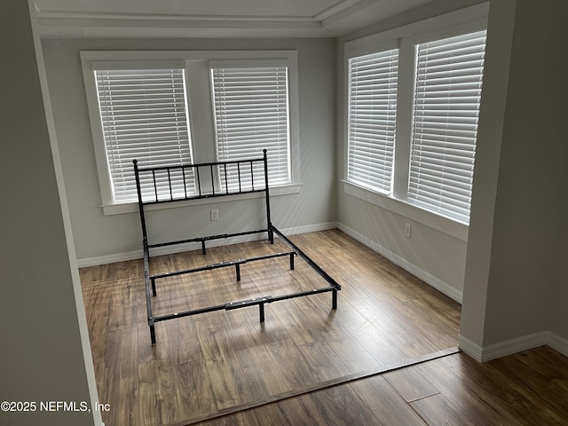 unfurnished bedroom featuring baseboards and wood finished floors