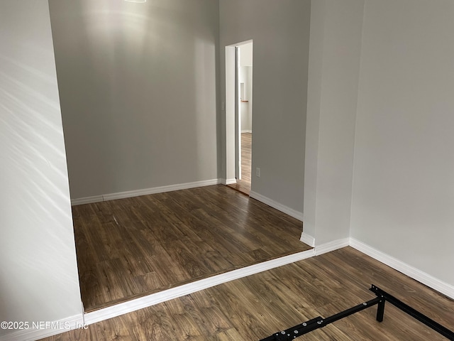 spare room featuring wood finished floors and baseboards