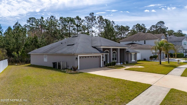 view of front of house featuring a garage, driveway, a front yard, and fence