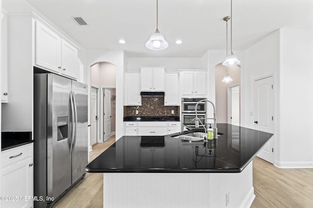 kitchen featuring dark countertops, visible vents, stainless steel appliances, and a sink