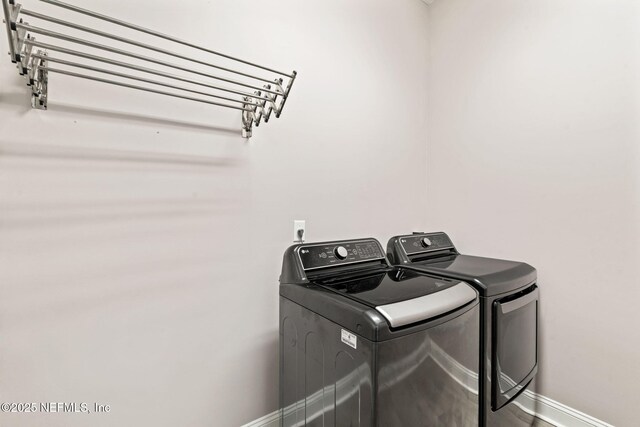 laundry area with laundry area, baseboards, and independent washer and dryer