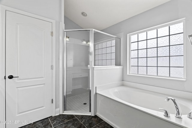 bathroom featuring lofted ceiling, a stall shower, tile patterned flooring, and a bath