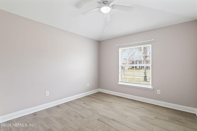 empty room featuring ceiling fan, light wood finished floors, and baseboards