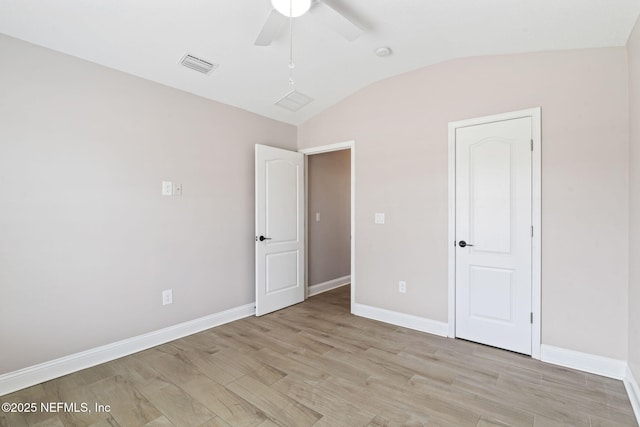 unfurnished bedroom with lofted ceiling, visible vents, light wood-style floors, a ceiling fan, and baseboards