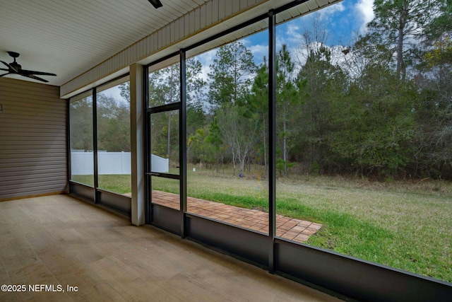 unfurnished sunroom featuring a ceiling fan