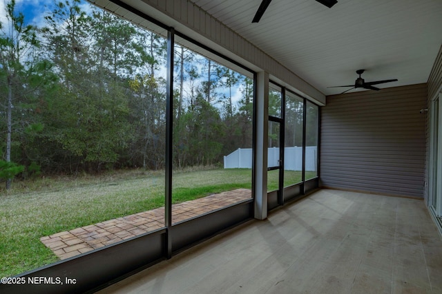 unfurnished sunroom featuring ceiling fan