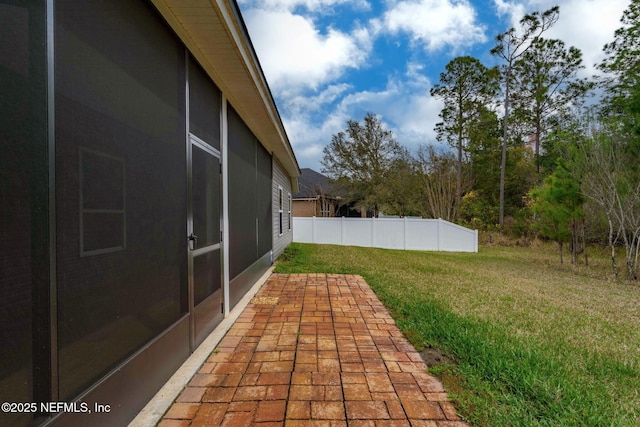 view of yard featuring a patio area, fence, and a sunroom