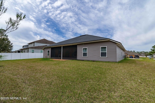 back of house featuring a sunroom, fence, and a yard