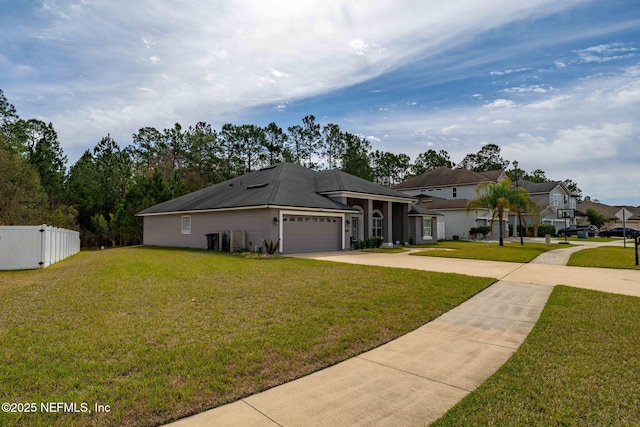 view of front of home with a garage, a front yard, fence, and driveway