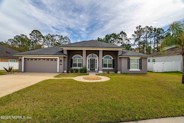 view of front of house with concrete driveway, fence, an attached garage, and stucco siding