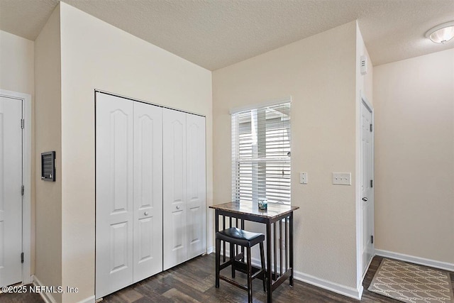 entrance foyer with baseboards, dark wood finished floors, and a textured ceiling