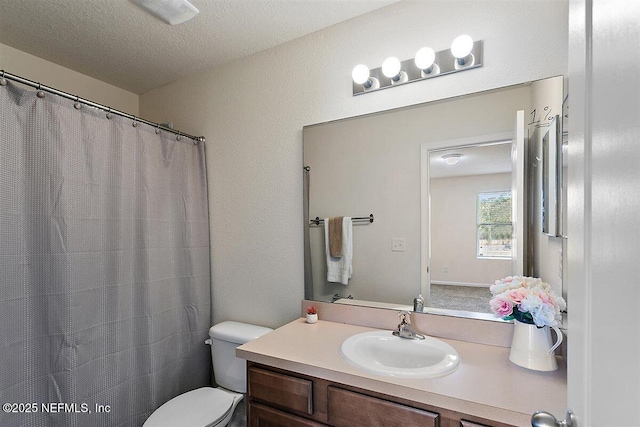 full bathroom featuring curtained shower, vanity, toilet, and a textured ceiling