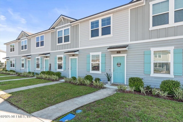 view of property featuring a front lawn and board and batten siding