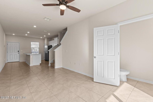 unfurnished living room featuring light tile patterned floors, recessed lighting, visible vents, a sink, and stairs