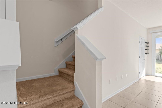 stairway featuring baseboards and tile patterned floors