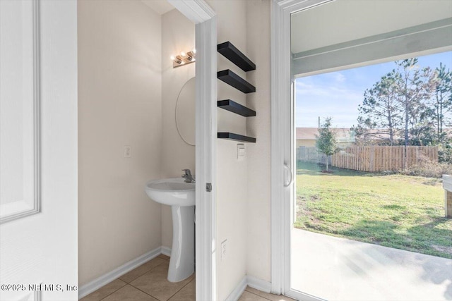 bathroom with baseboards, a sink, and tile patterned floors