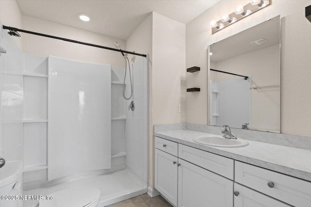 bathroom featuring visible vents, toilet, tile patterned flooring, walk in shower, and vanity