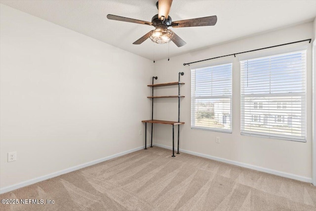 empty room with light carpet, baseboards, and a ceiling fan