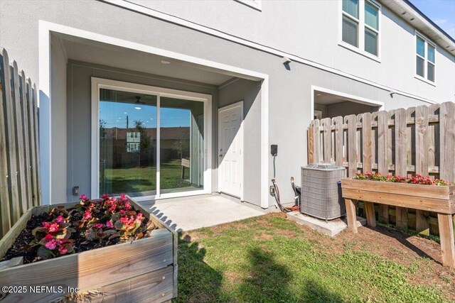 exterior space featuring central AC, fence, and stucco siding