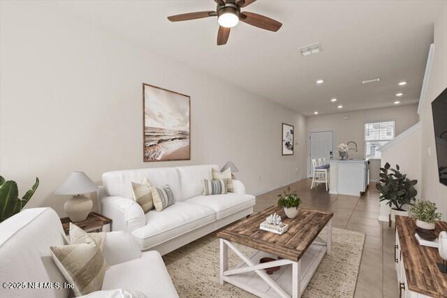 living room featuring light tile patterned floors, a ceiling fan, visible vents, and recessed lighting