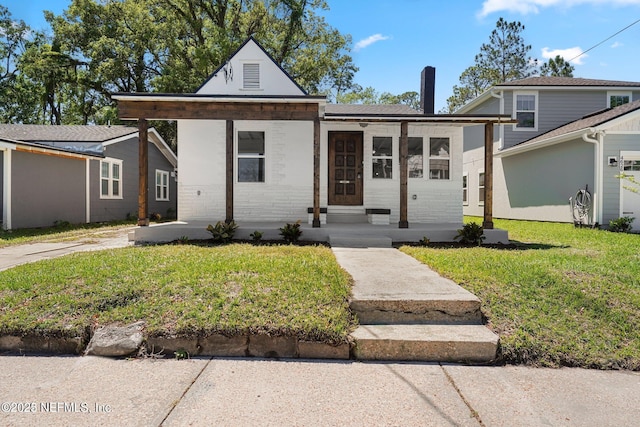 view of front facade with brick siding and a front yard