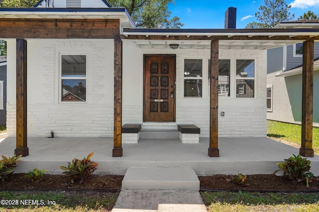 view of exterior entry with a chimney