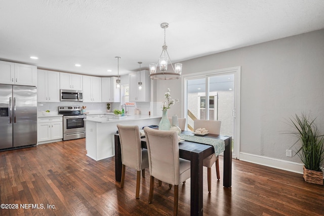 dining area featuring dark wood-style floors, recessed lighting, a notable chandelier, and baseboards