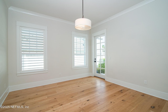 spare room with light wood-style floors, baseboards, and crown molding