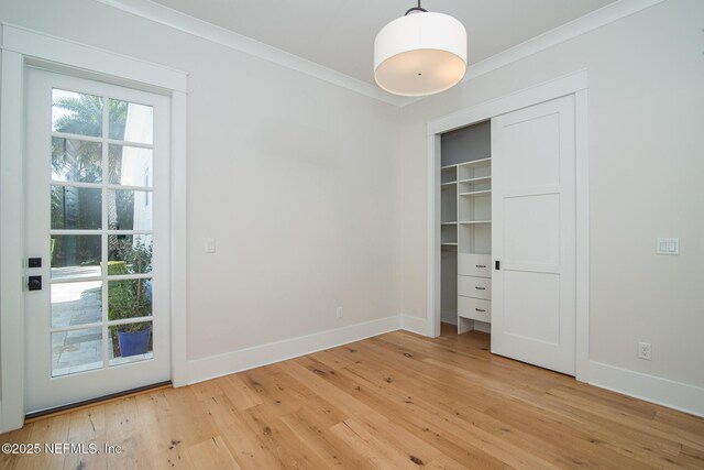 unfurnished bedroom with baseboards, a closet, light wood-type flooring, and crown molding