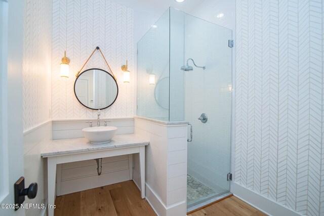 bathroom with a stall shower, vanity, and wood finished floors