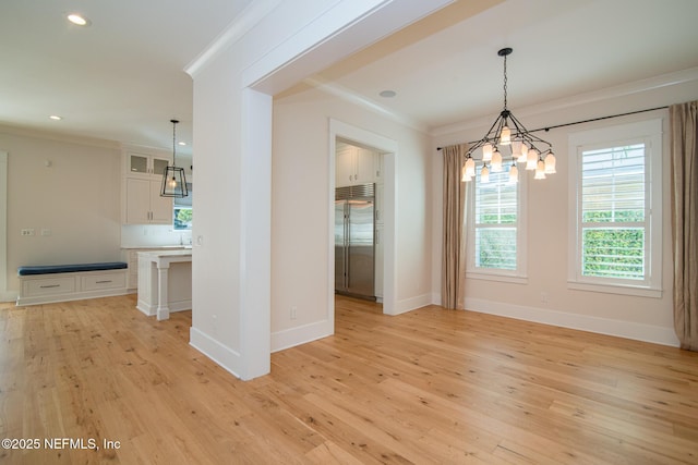 unfurnished dining area featuring light wood finished floors, baseboards, crown molding, and recessed lighting