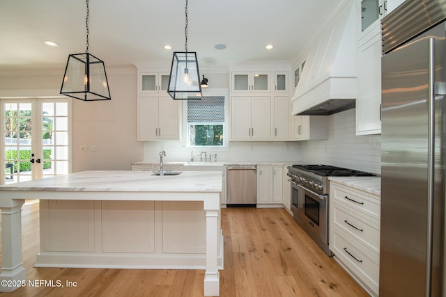 kitchen with hanging light fixtures, premium range hood, high end appliances, and decorative backsplash