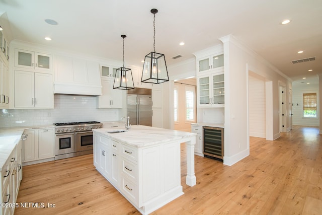 kitchen with visible vents, high end appliances, wine cooler, crown molding, and premium range hood