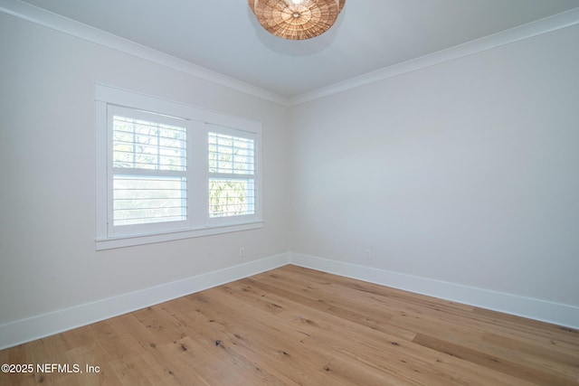 spare room featuring light wood-style flooring, ornamental molding, and baseboards