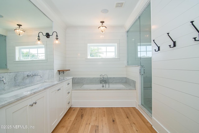 full bathroom with a garden tub, visible vents, vanity, a shower stall, and wood finished floors