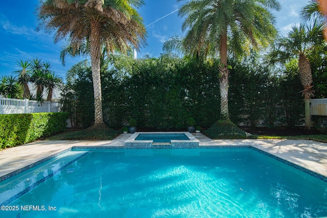 view of swimming pool with a pool with connected hot tub and fence