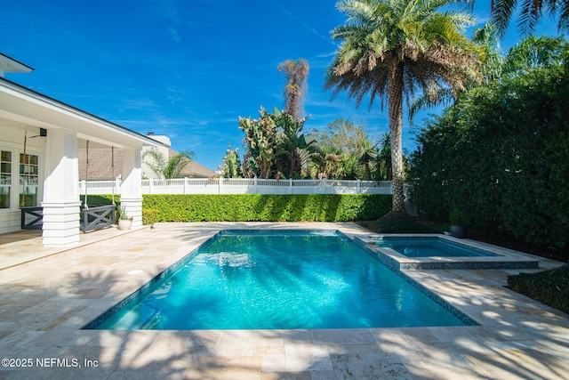 view of pool featuring a patio area, a pool with connected hot tub, and fence