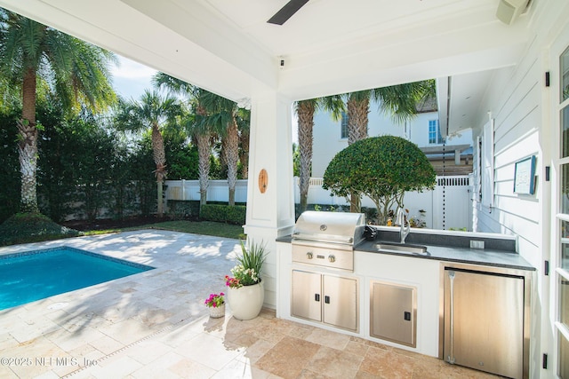 view of patio with ceiling fan, an outdoor kitchen, fence, a sink, and a grill