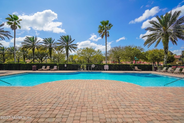 community pool featuring a patio area and fence