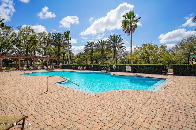 pool with a patio, fence, and a pergola