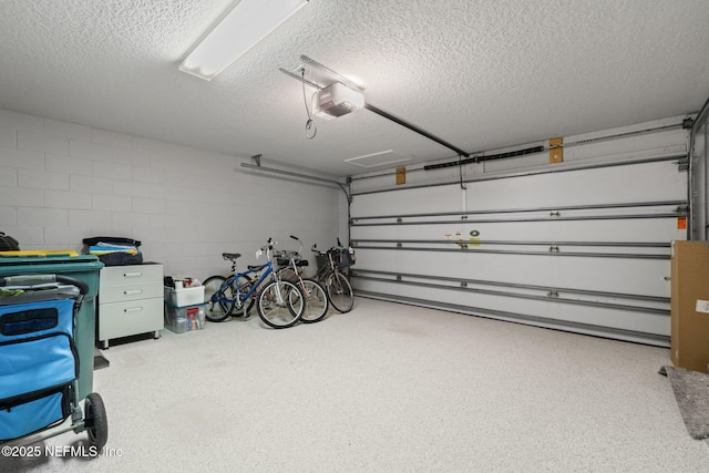 garage featuring concrete block wall and a garage door opener