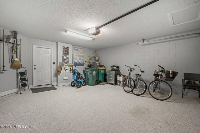 garage with a garage door opener and concrete block wall