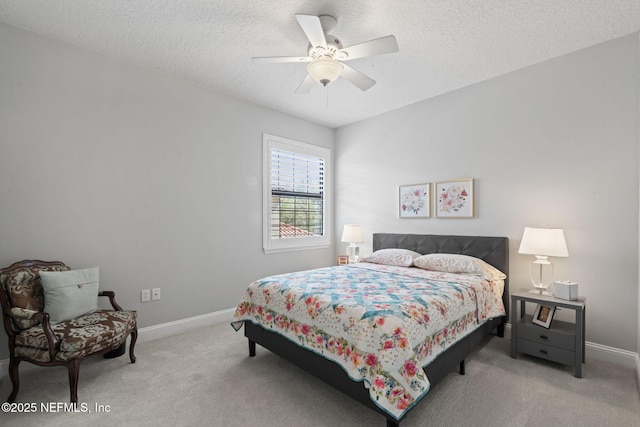 carpeted bedroom with ceiling fan, a textured ceiling, and baseboards