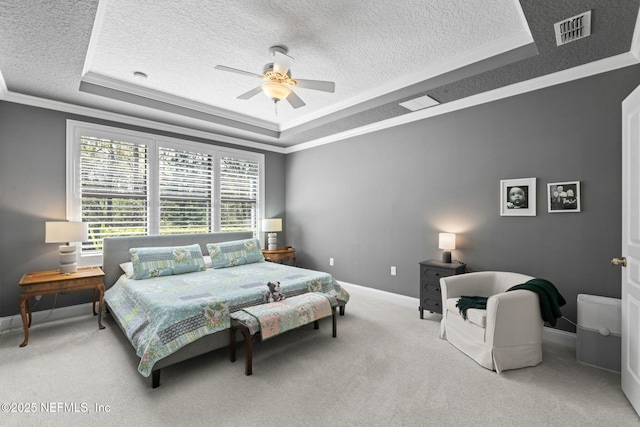 bedroom featuring visible vents, ornamental molding, a tray ceiling, a textured ceiling, and carpet floors